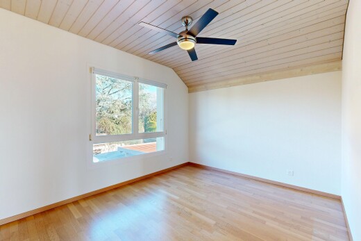 pièce vide avec plafond voûté, vaulted ceiling, lumière naturelle, natural light, et sol en finition bois