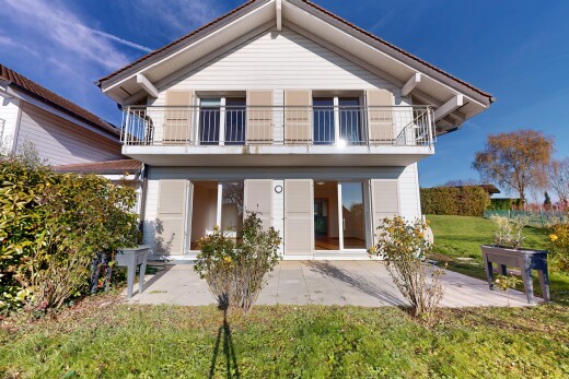 façade avec balcon, terrasse, pelouse, property visible, et bardage horizontal