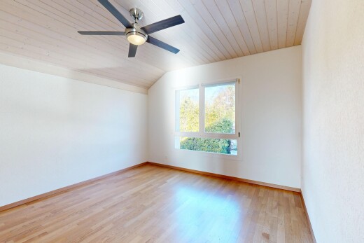 pièce vide avec sol en finition bois, wood finish floor, inside property, plafond voûté, et vaulted ceiling