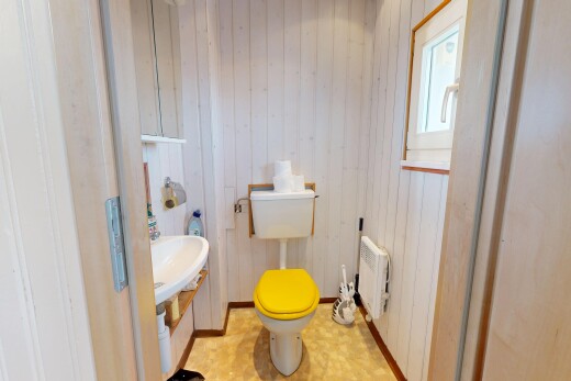 salle de bains avec toilette, wood wall, mur en bois, inside property, et radiateur