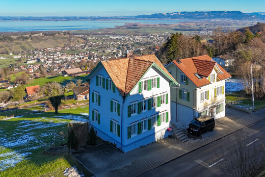 außenansicht mit day time, eingebaute garage, auffahrt, drone view, und stuckverkleidung