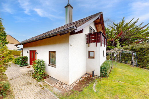 façade avec bardage en stuc, pelouse, property visible, et day time