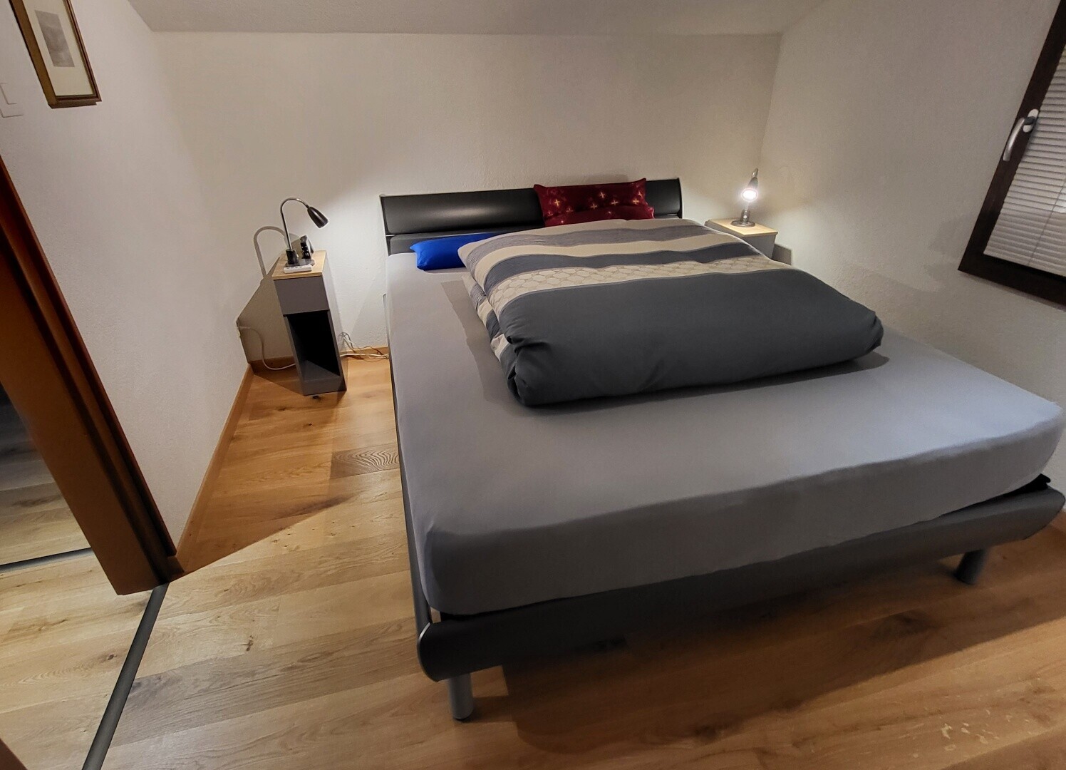 zimmer / schlafzimmer mit gipskartonwand, drywall, holzfußboden, wood finish floor, und inside property