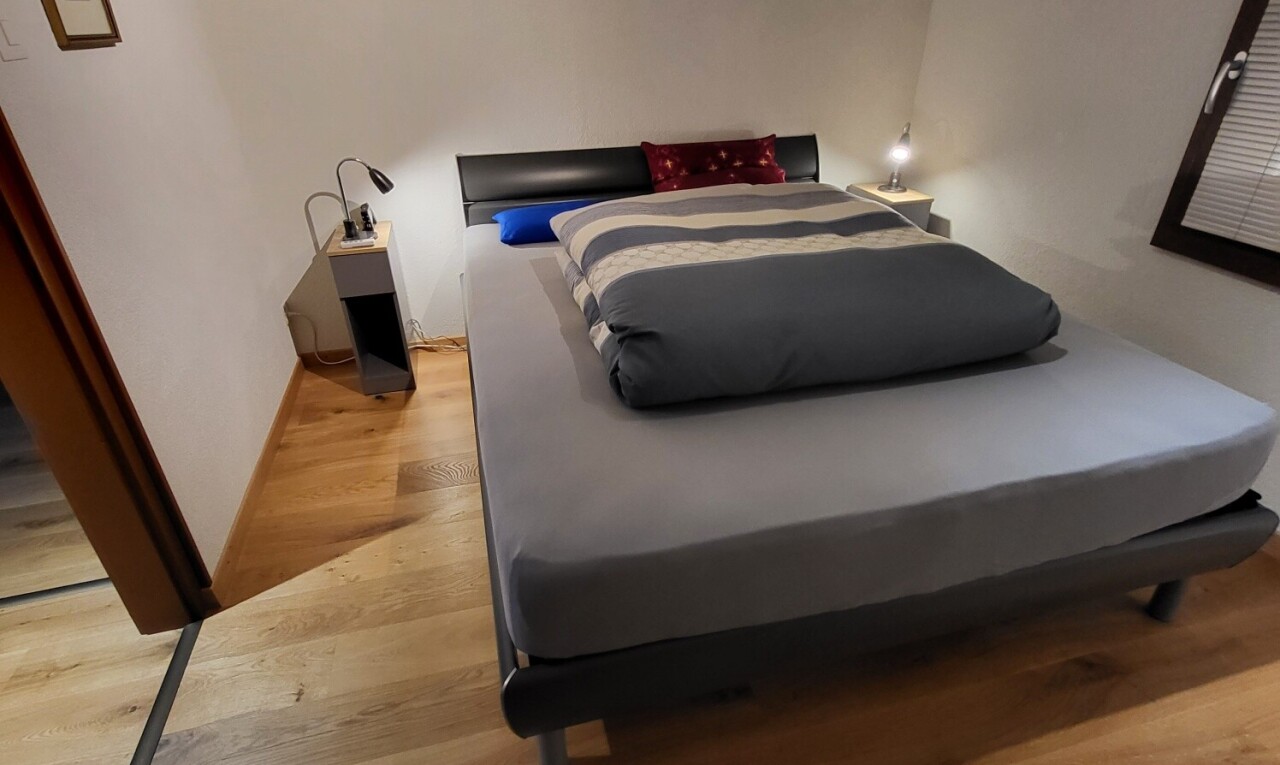 zimmer / schlafzimmer mit gipskartonwand, drywall, holzfußboden, wood finish floor, und inside property