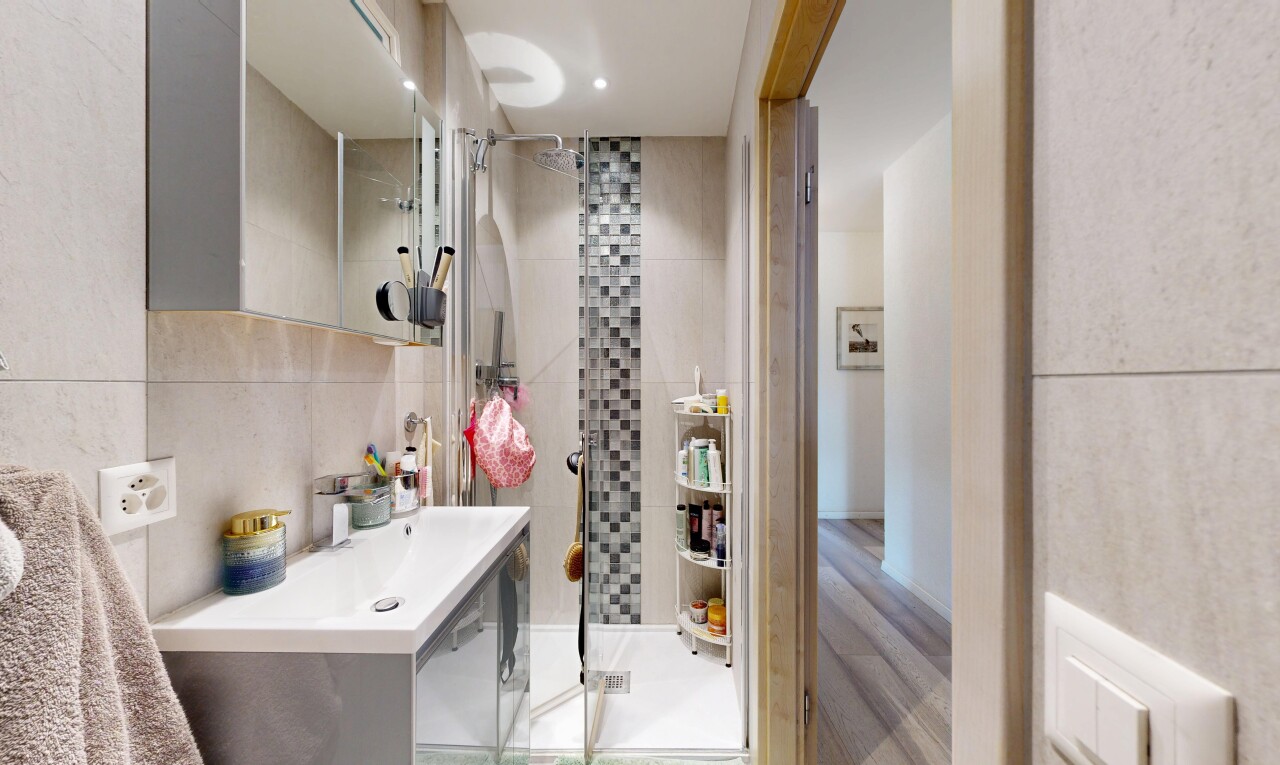full bath featuring a shower stall and tile walls