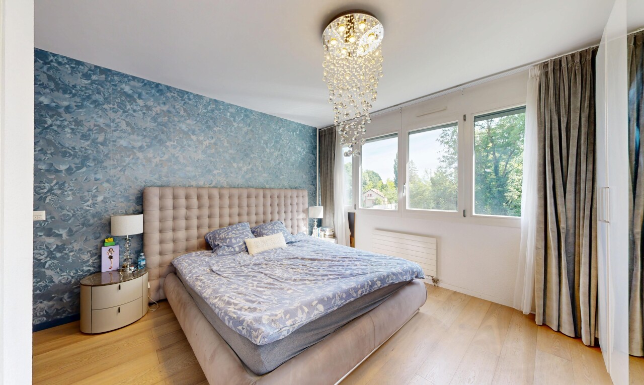 room with light wood-type flooring, a chandelier, radiator, and wallpapered walls