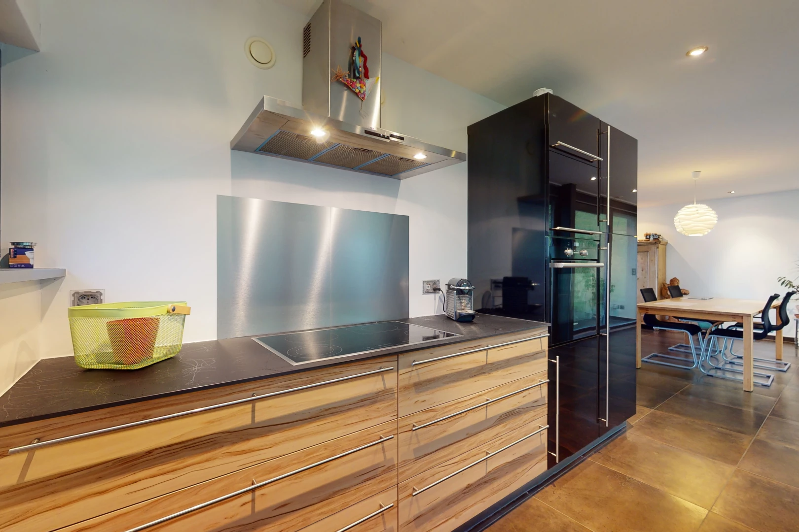 cuisine avec four, réfrigérateur, cuisinière électrique, hotte, suspension, et plan de travail foncé