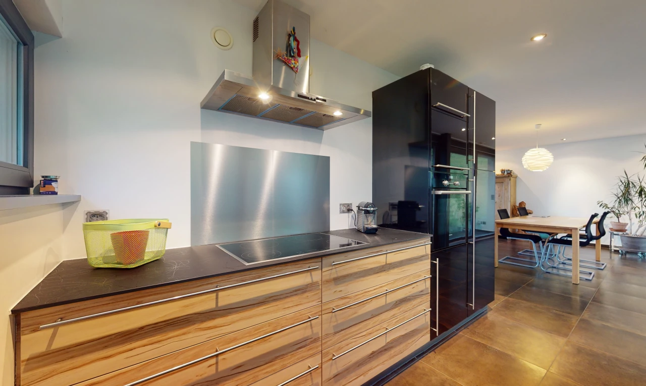 cuisine avec four, réfrigérateur, cuisinière électrique, hotte, suspension, et plan de travail foncé
