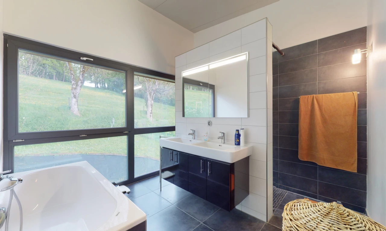 salle de bains avec carrelage, lumière naturelle, baignoire, douche, miroir, meuble-lavabo, et double vasque