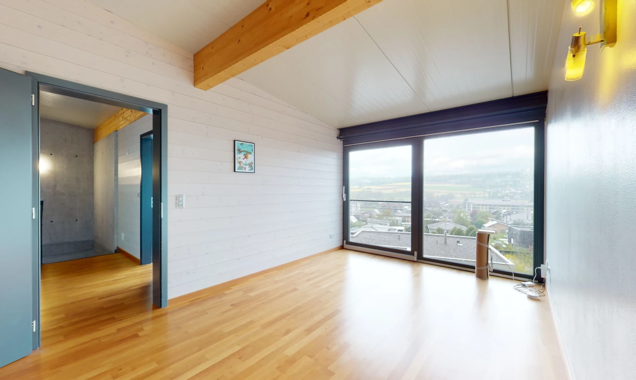 chambre vide avec parquet et poutres apparentes