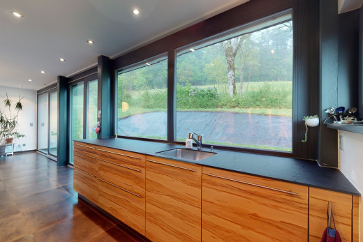 küche mit natürlichen hellen, dunklen arbeitsplatten und braunen schränken