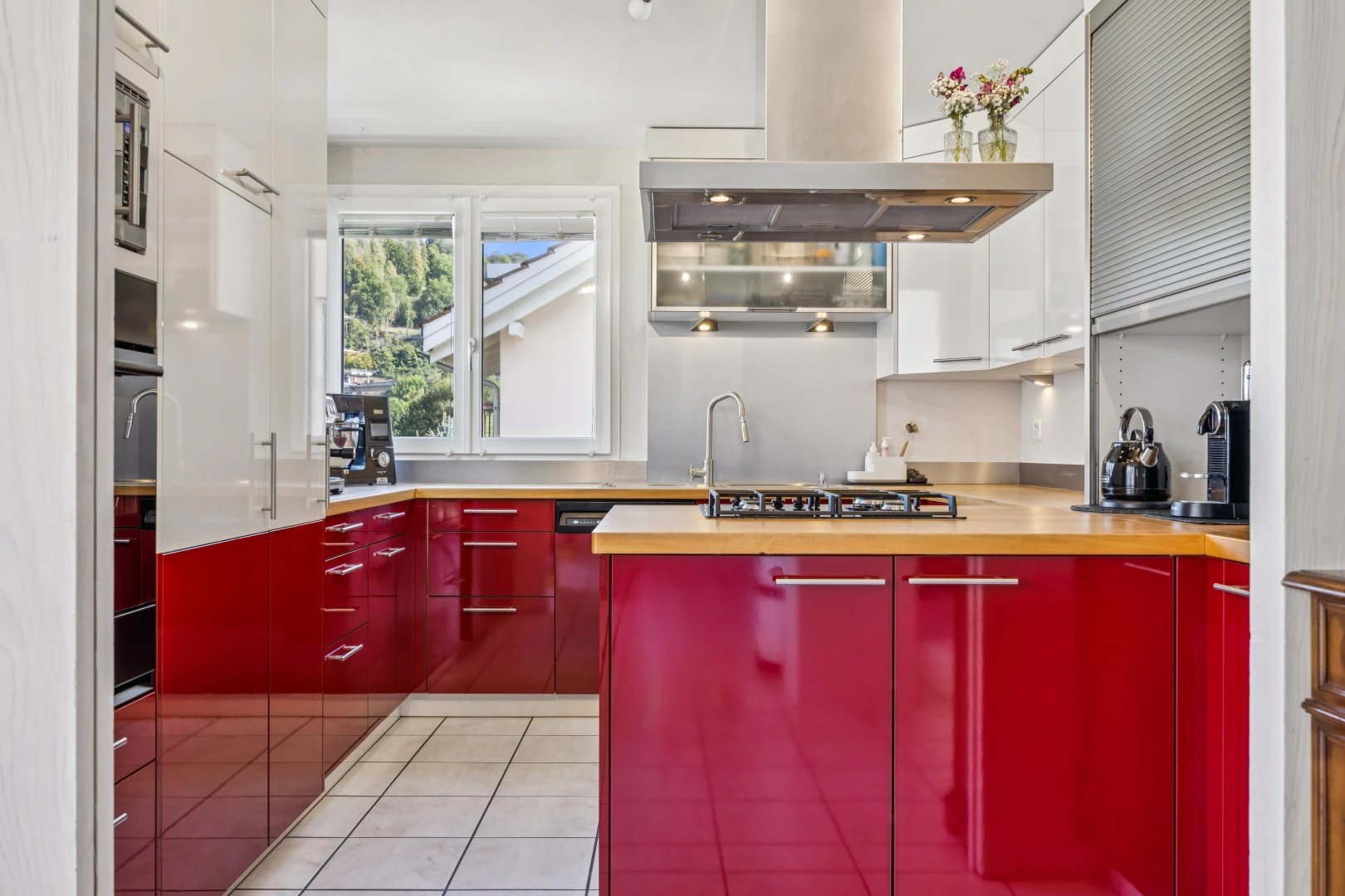 cuisine avec hotte, light floor, two tone kitchen, sol en carrelage, et tile floor
