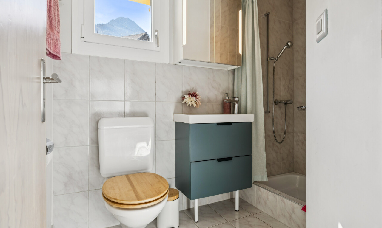 full bath featuring tiled shower / bath combo, tile walls, light tile patterned flooring, and vanity