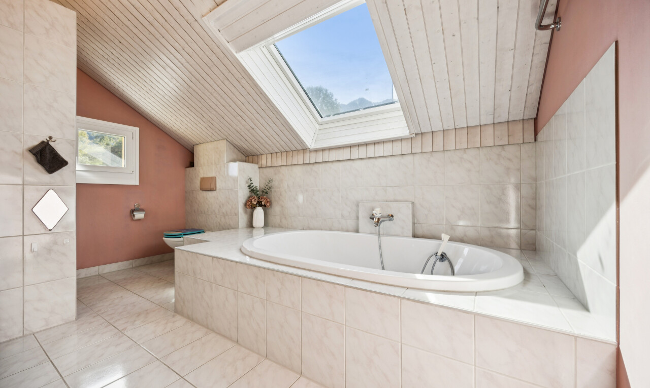 bathroom featuring a garden tub, wooden ceiling, vaulted ceiling with skylight, and light tile patterned flooring