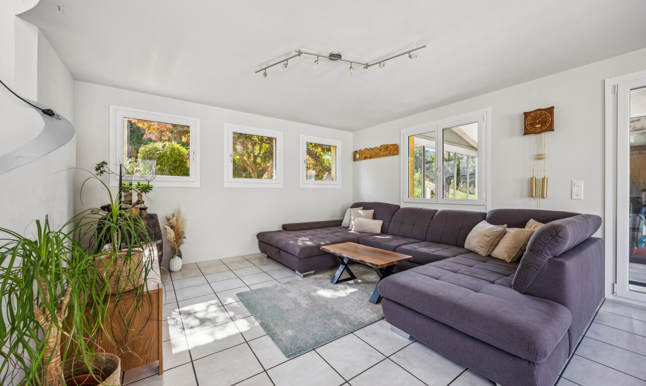 living area with rail lighting and light tile patterned floors