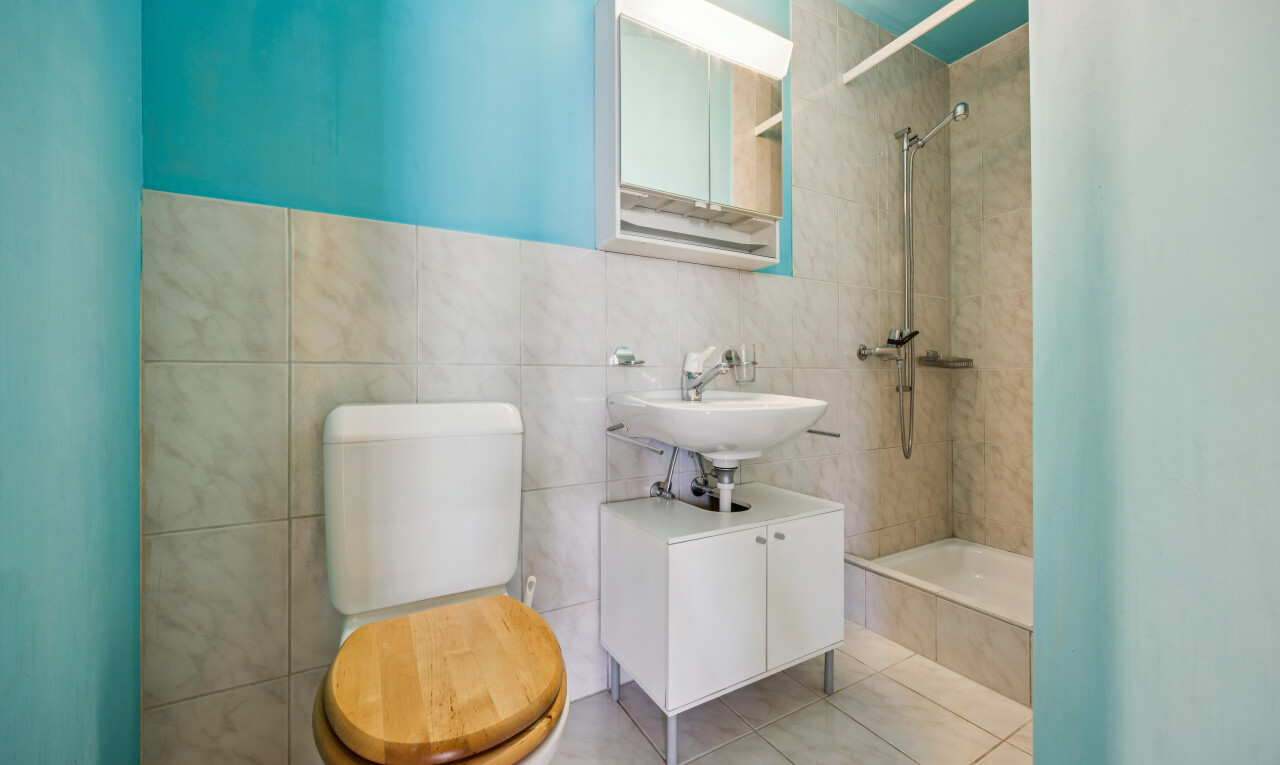 bathroom with a tile shower, tile walls, and light tile patterned floors