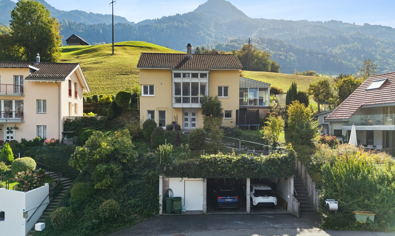 view of property with a tiled roof, a mountain view, a chimney, and stucco siding