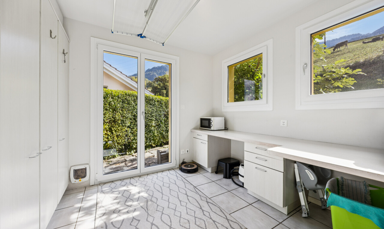 unfurnished office featuring built in desk, access to outside, and light tile patterned floors