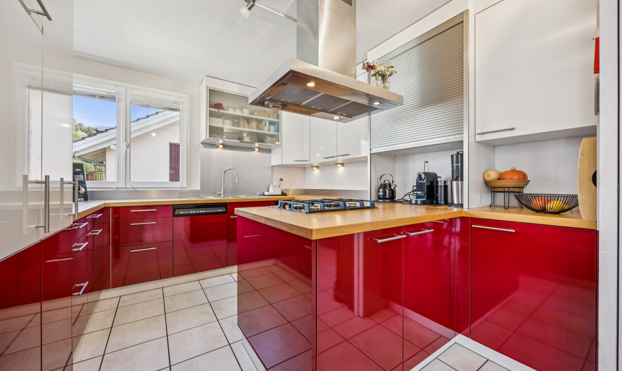 dual tone kitchen with island range hood, two tone color scheme, light tile patterned floors, light countertops, and dishwasher