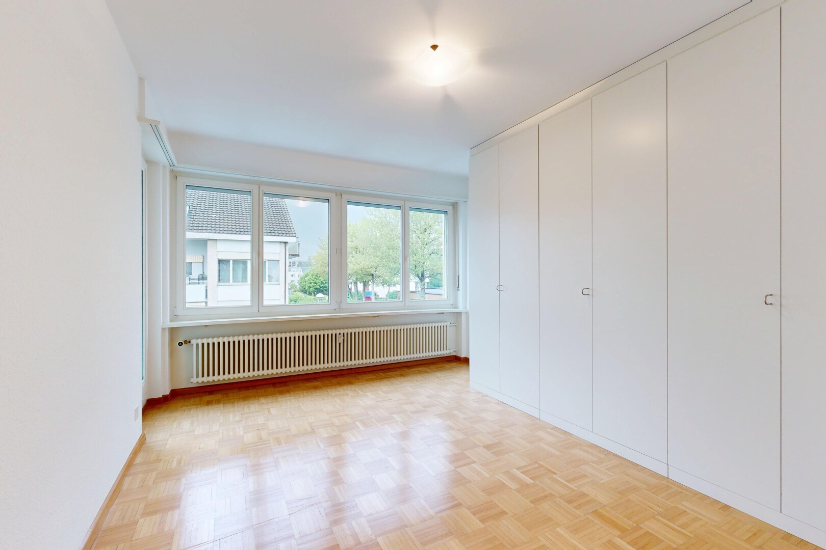 empty room featuring radiator and parquet floors