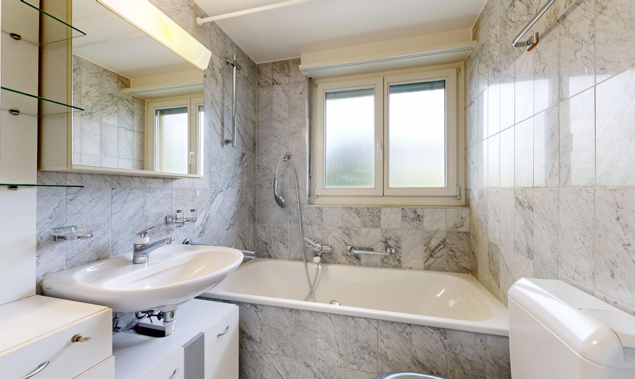 bathroom featuring tile walls and tiled shower / bath combo