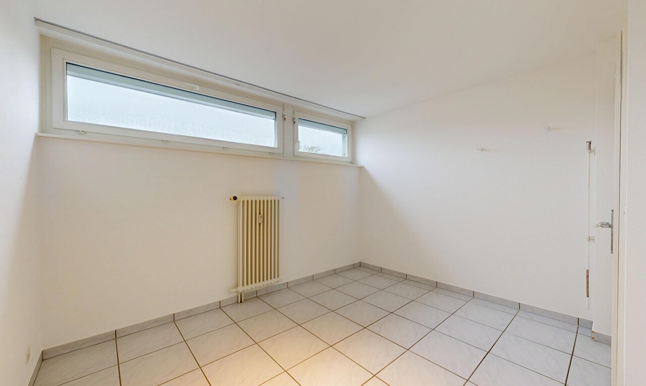 empty room featuring radiator heating unit and baseboards