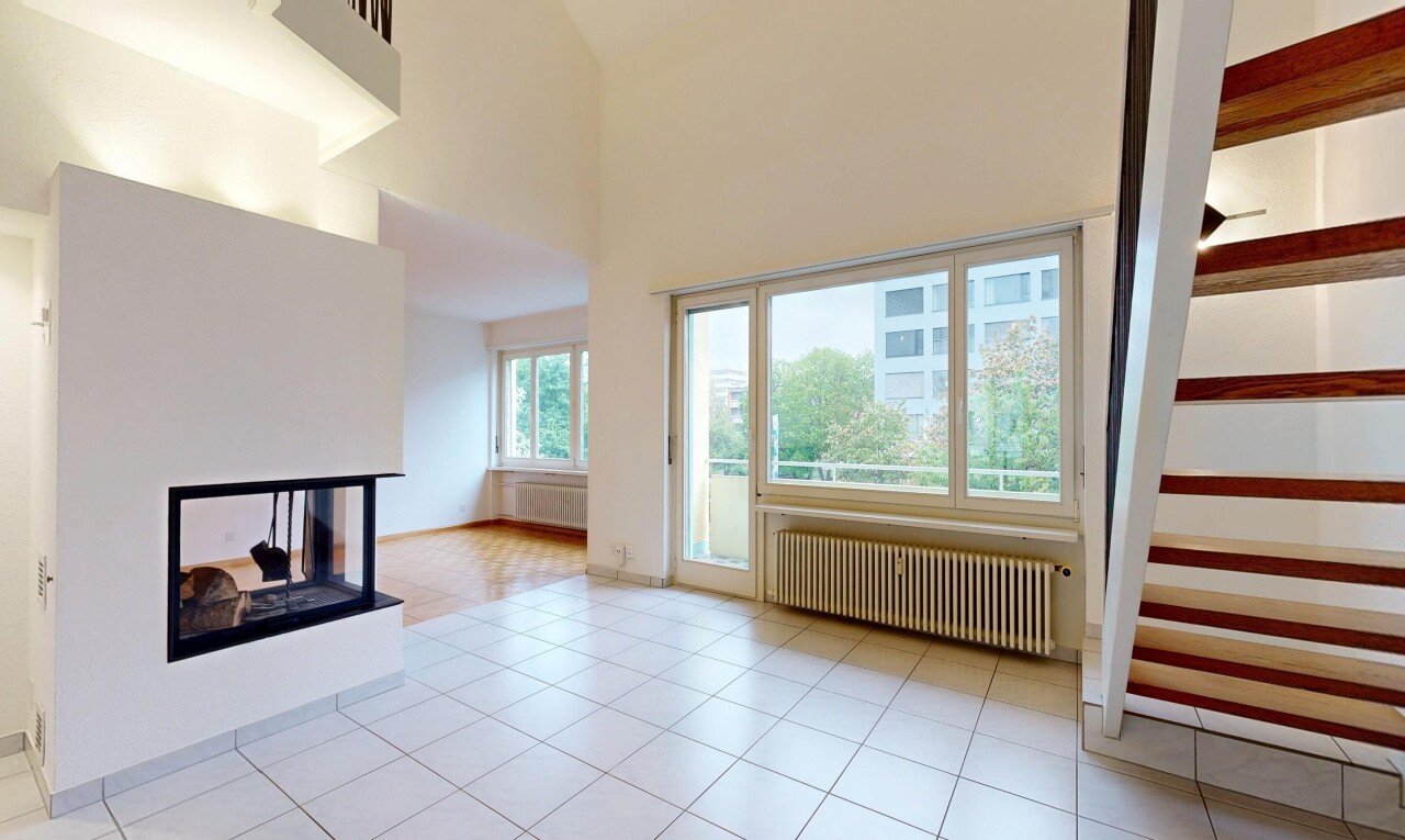 unfurnished living room with a multi sided fireplace, radiator heating unit, a high ceiling, and radiator