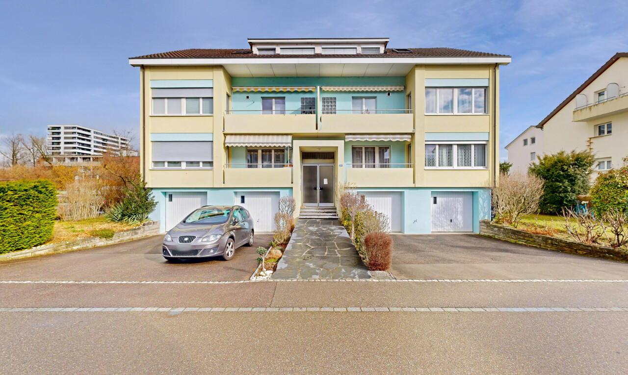view of property featuring asphalt driveway and a garage