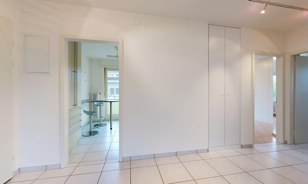 empty room with track lighting, light tile patterned flooring, and radiator heating unit