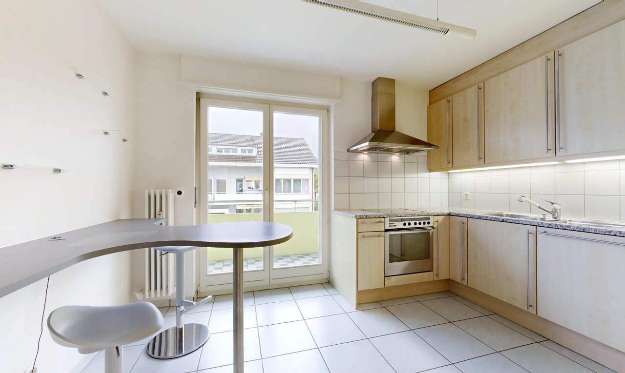kitchen featuring light wood finish cabinetry, tasteful backsplash, stainless steel oven, and radiator