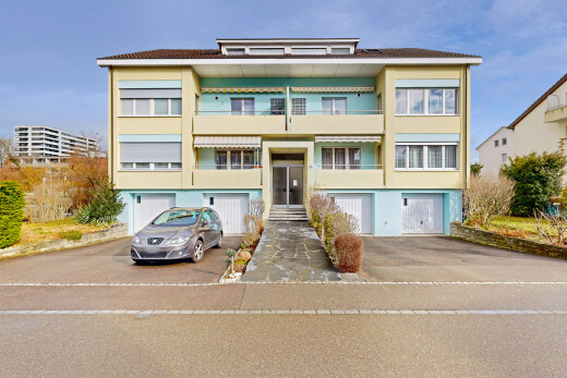 view of property featuring asphalt driveway and a garage