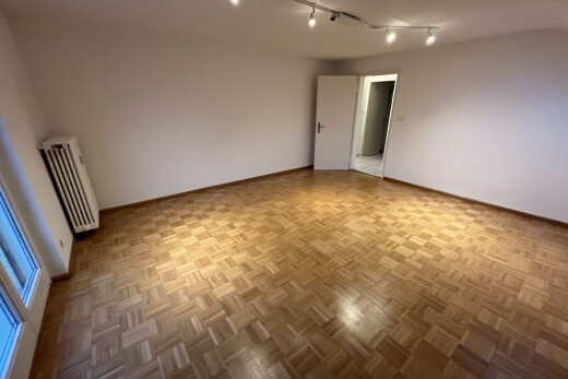 unfurnished room with radiator, parquet floors, and track lighting