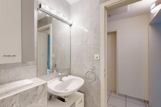 half bath with vanity, tile walls, and light tile patterned flooring