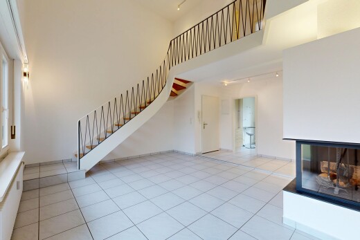 salon avec escaliers, plafond haut, high ceiling, éclairage sur rail, et track lighting