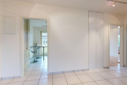empty room with track lighting, light tile patterned flooring, and radiator heating unit