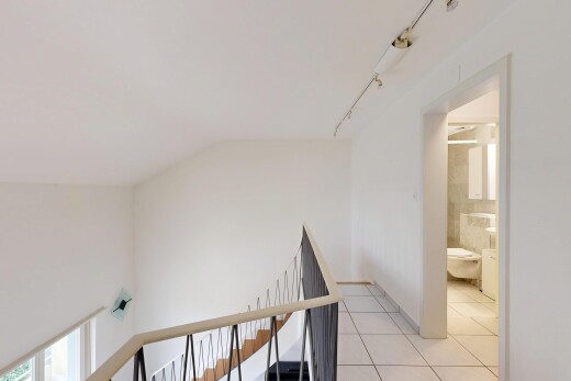 stairs featuring tile patterned floors and track lighting