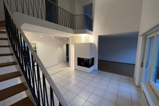 staircase with a high ceiling, a multi sided fireplace, and tile patterned floors