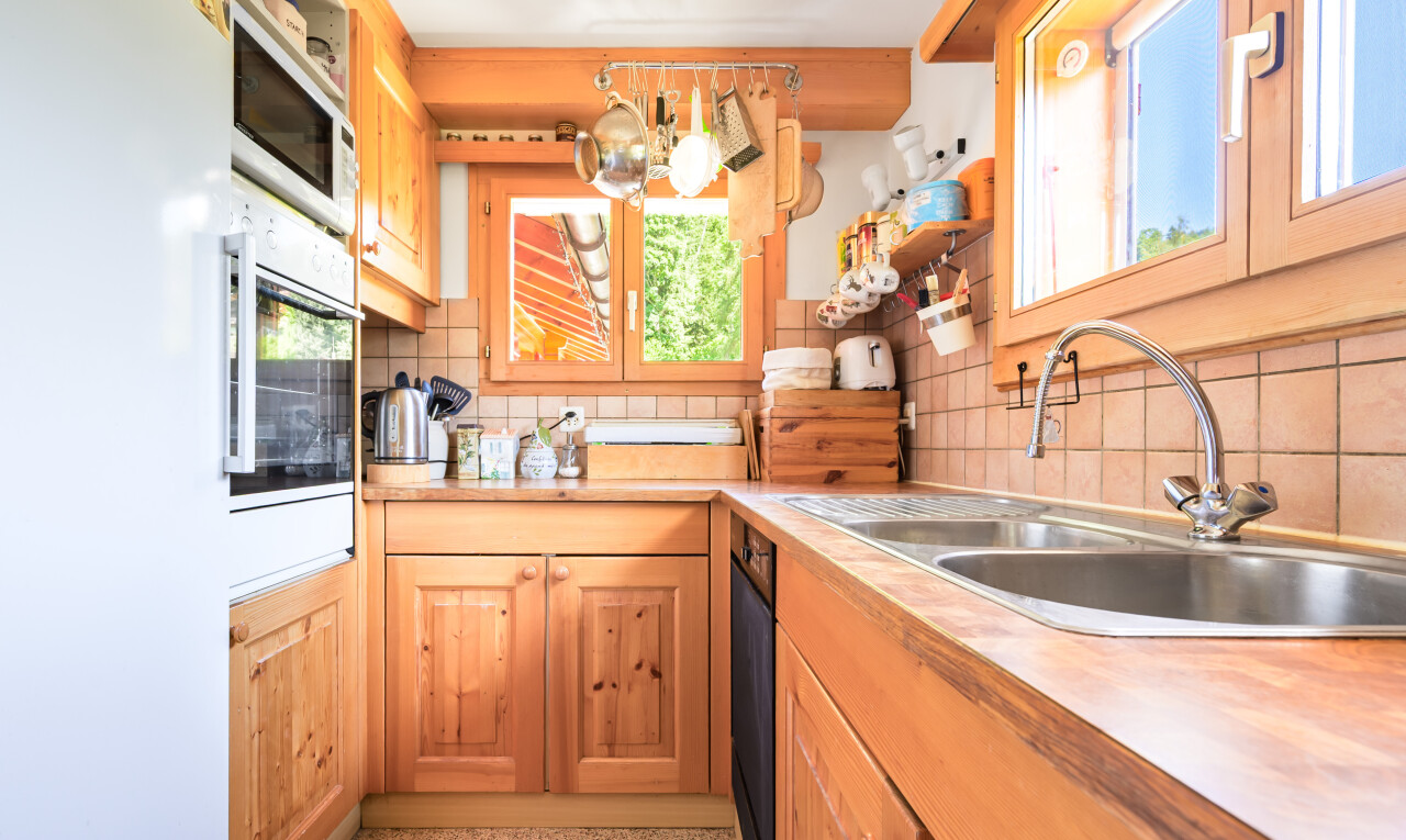 cuisine avec réfrigérateur, four, évier, dosseret, et backsplash