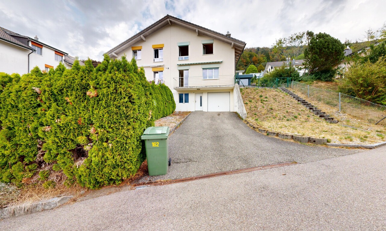 außenansicht mit auffahrt, property visible, eingebaute garage, kellergarage, und stuckverkleidung