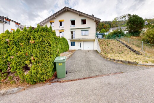 außenansicht mit auffahrt, property visible, eingebaute garage, kellergarage, und stuckverkleidung