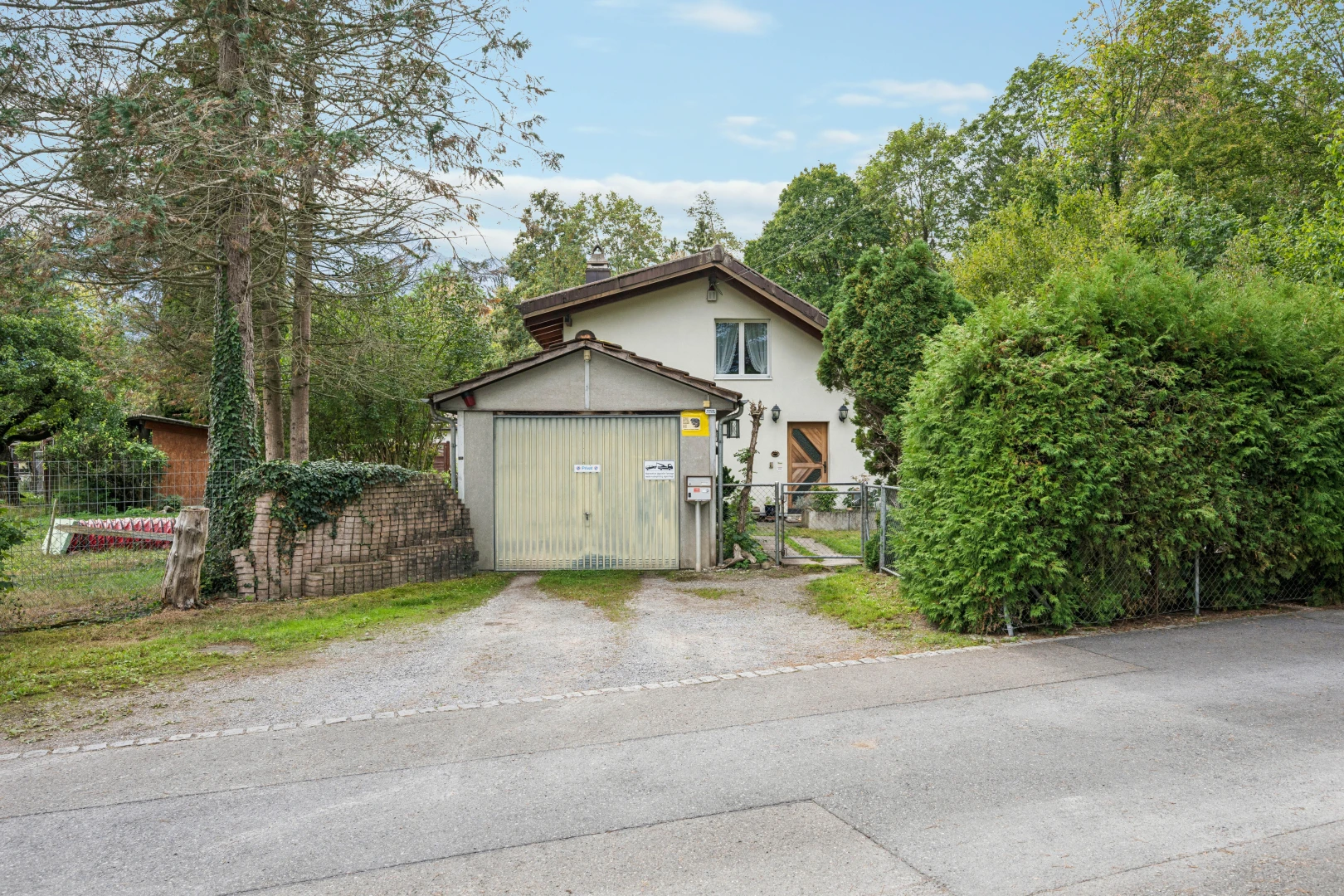 außenansicht mit tor, zaun, property visible, und day time