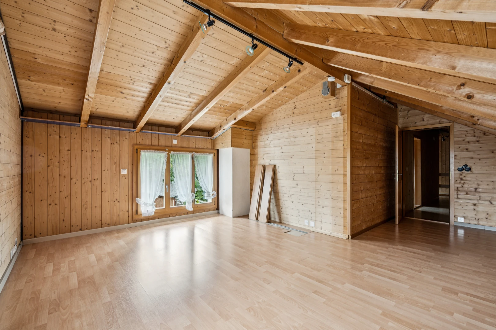leerer raum mit vaulted ceiling, dachschräge, beamed ceiling, balkendecke, und wood wall