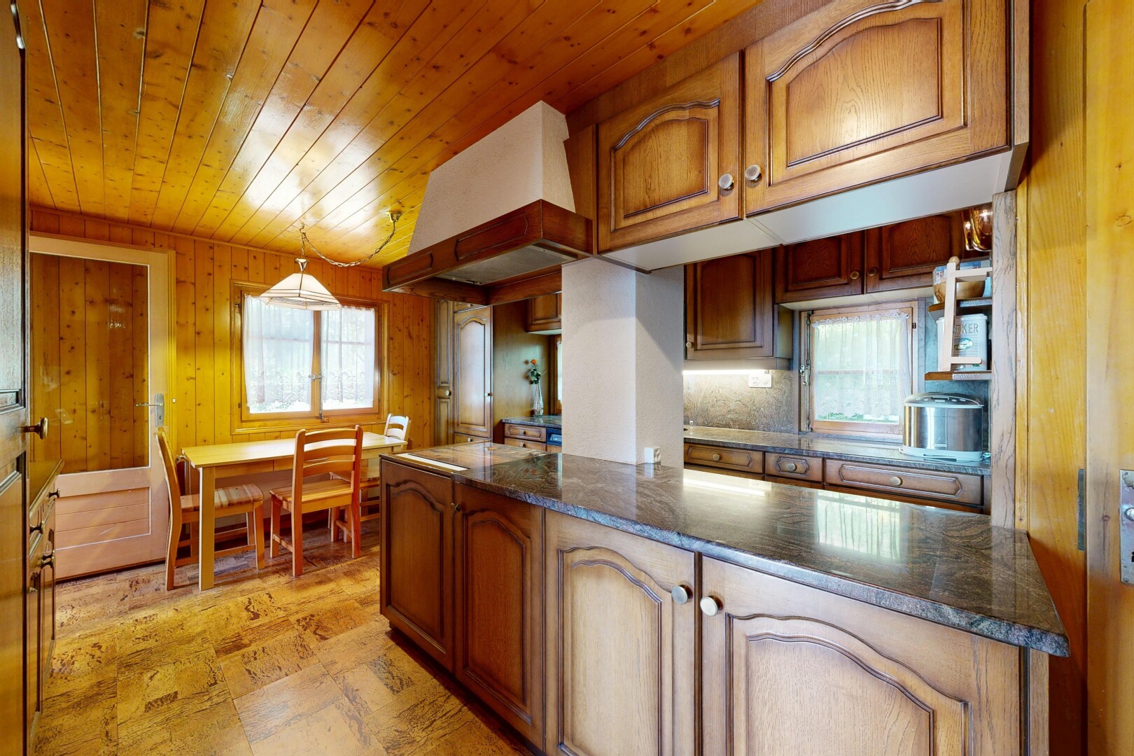 cuisine avec armoires en arc, arched cabinets, armoires marron moyen, medium brown cabinets, et dark countertops
