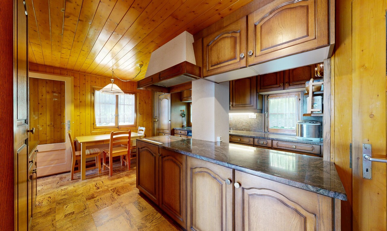 cuisine avec armoires en arc, arched cabinets, armoires marron moyen, medium brown cabinets, et dark countertops