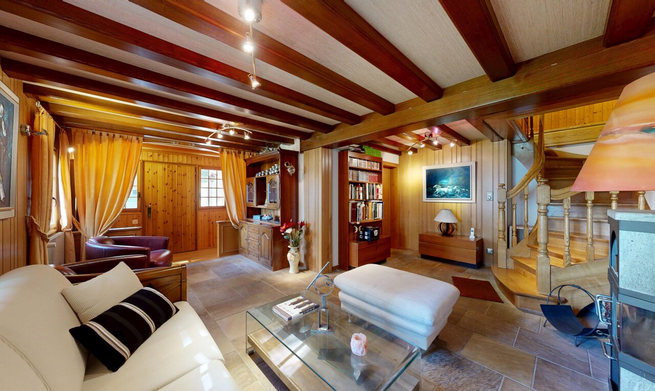 salon avec escaliers, inside property, wood wall, mur en bois, et beamed ceiling