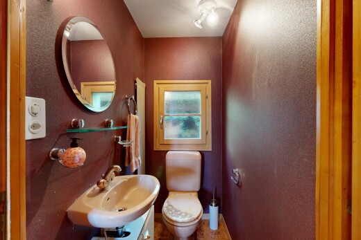 salle de bains avec toilette, miroir, évier, inside property, et baseboards wall