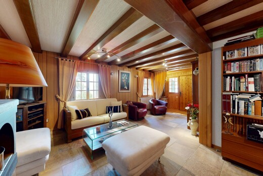 salon avec plafond à poutres, beamed ceiling, inside property, mur en bois, et wood wall