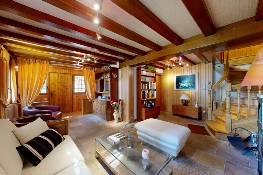 salon avec escaliers, inside property, wood wall, mur en bois, et beamed ceiling