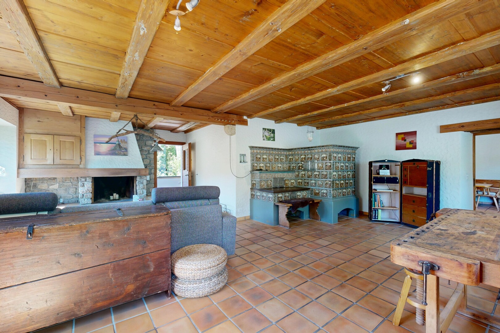 living area featuring a wooden ceiling with exposed beams, a large fireplace, and light tile patterned floors
