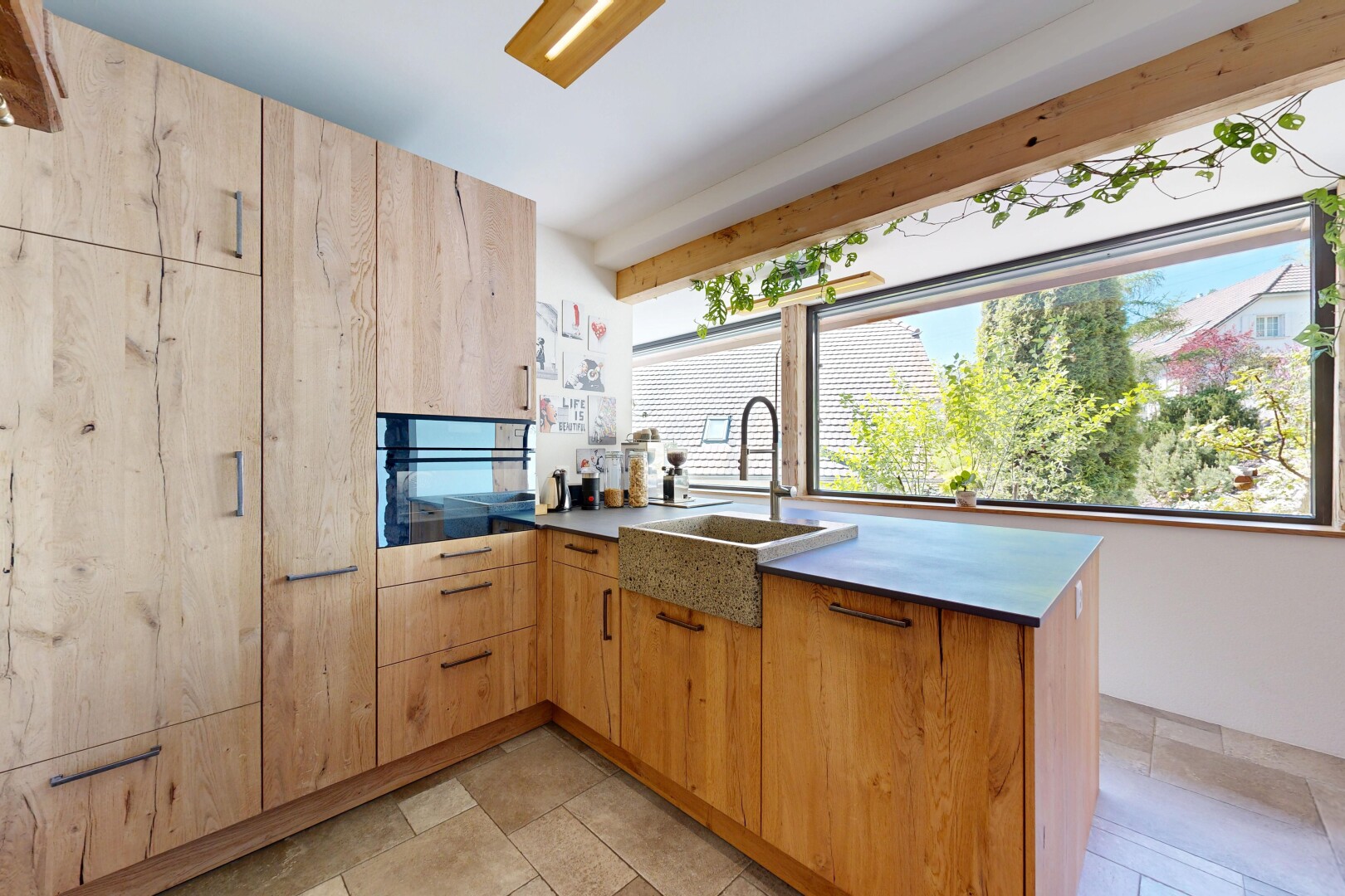 kitchen with a peninsula, black oven, and light wood finish cabinetry